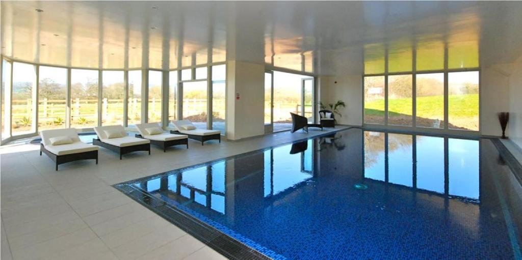 The heated indoor pool at Wellesley Park, with loungers and countryside views